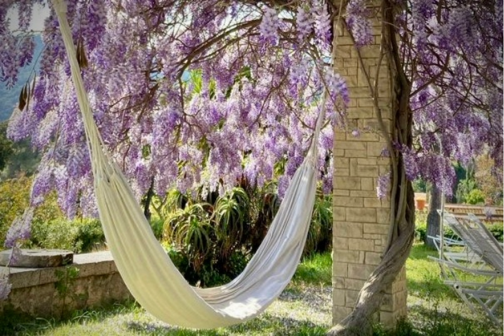 Relaxing hammock view at Masia Can Casadellà with mountains and Mediterranean Sea near Barcelona in the background