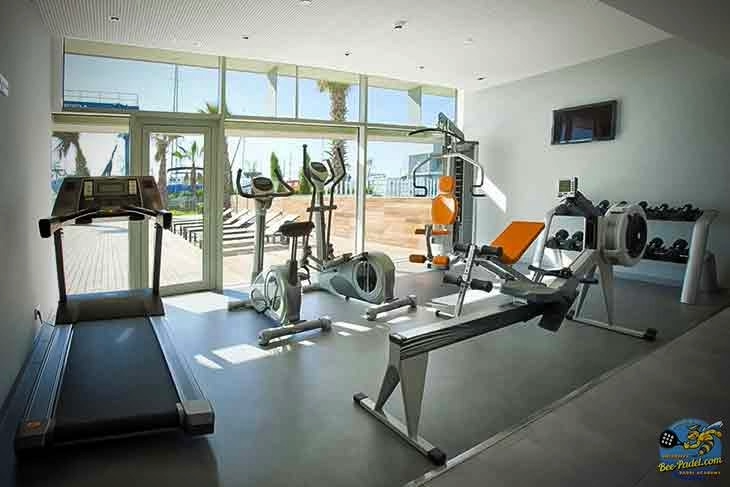 Fitness Room with Pool and Harbour View | Hotel Atenea Port Mataró Fitness room at Hotel Atenea Port Mataró with views of the outdoor pool and harbour