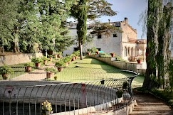 Side view of Masia Can Casadellà with expansive garden park, ideal for relaxing and imagining its rich historical past
