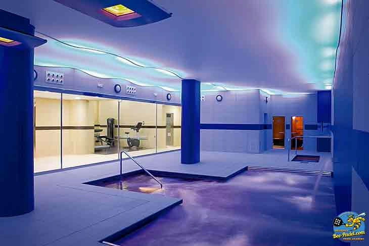 Indoor pool, sauna, and compact fitness room at URH Hotel Mataró, ideal for relaxation and light workouts.