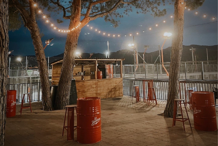 Players and guests enjoying a lively weekend celebration on the terrace at Can Teixidó Padel Club.