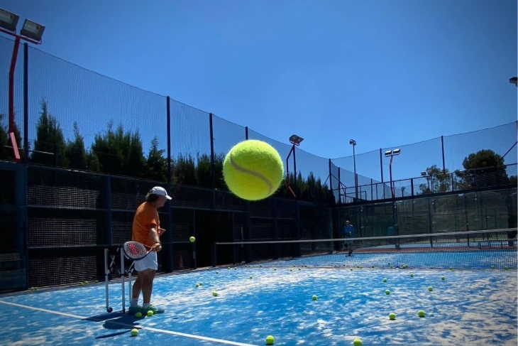 Artistic shot of a one-on-one padel coaching session at Can Teixidó Padel Club, featuring a trainer giving personalized guidance on the court.
